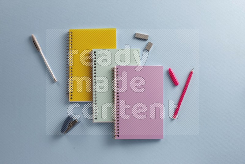 A multicolored notebooks with school supplies on blue background (Back to school)