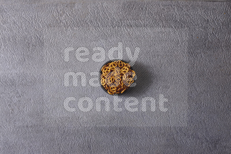 Assorted snacks in pottery bowls on grey background
