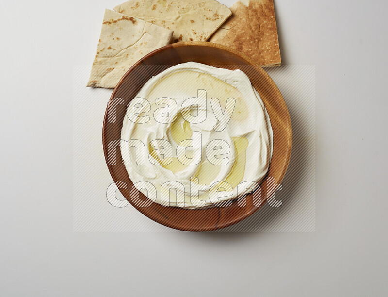 Lebnah garnished with olive oil in a wooden plate on a white background