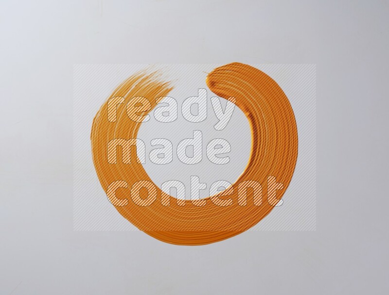 An orange circular painting brush stroke on white background