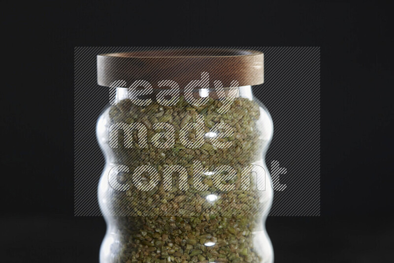 Freekeh in a glass jar on black background