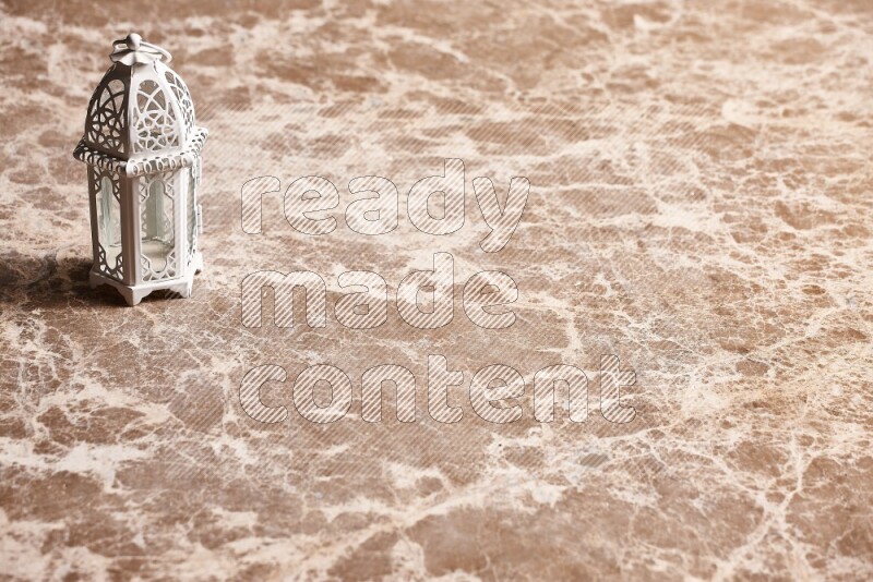 A candle lantern on beige marble background