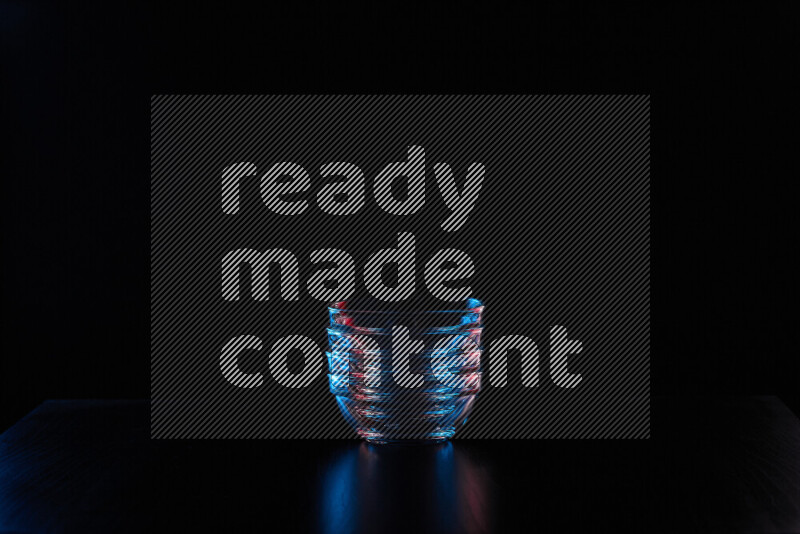 Glassware with rim light in red and blue against black background