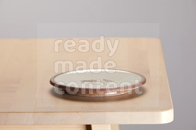 multi-colored pottery Plate on a wooden table edge