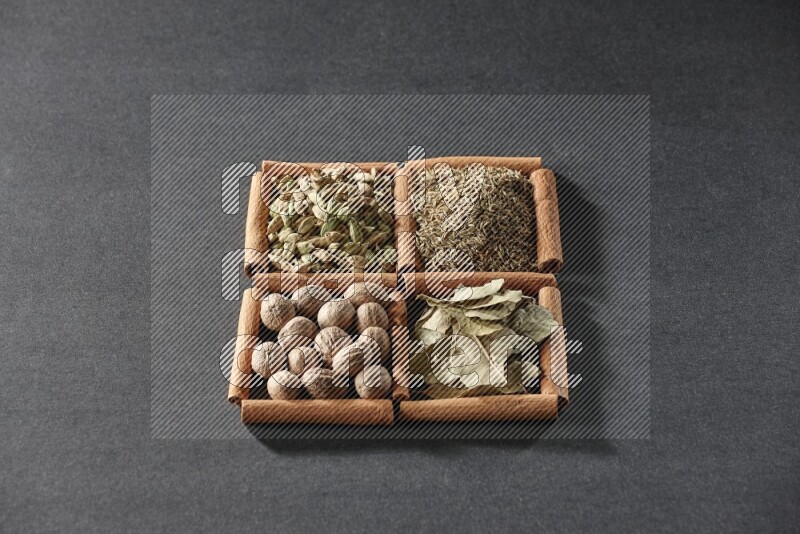 4 squares of cinnamon sticks full of cumin, cardamom, bay laurel leaves and nutmegs on black flooring