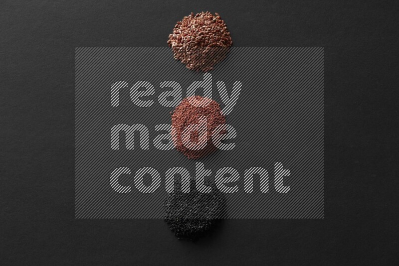 Black seeds, mustard seeds, garden cress and flax on a Black background