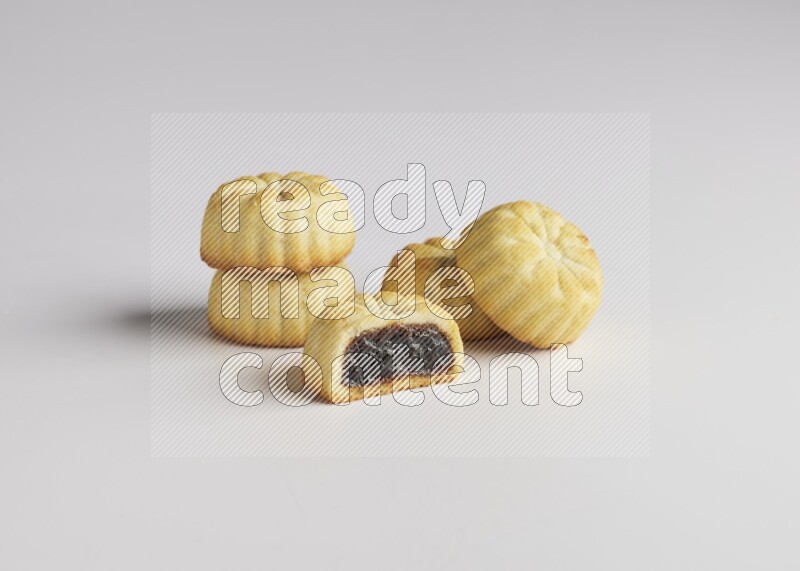 Five Pieces of Maamoul filled with date one of them is cut direct on white background