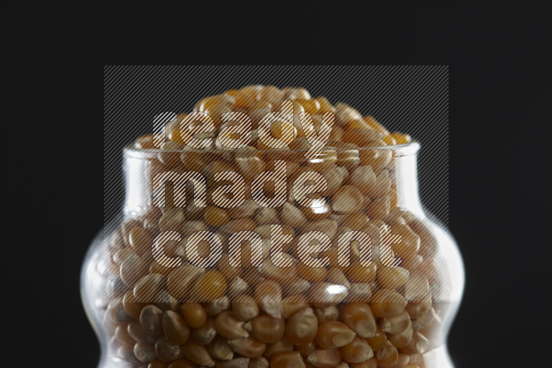 Pop corn in a glass jar on black background