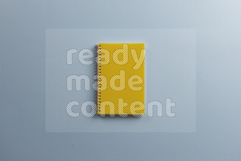 دفتر ملاحظات أصفر مع مستلزمات مدرسية مختلفة على خلفية زرقاء