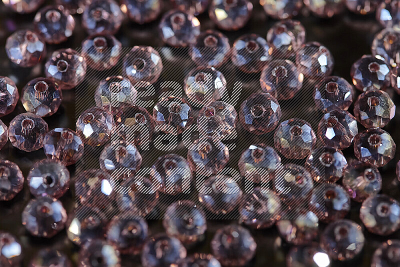 Rose transparent crystal beads scattered on a black background