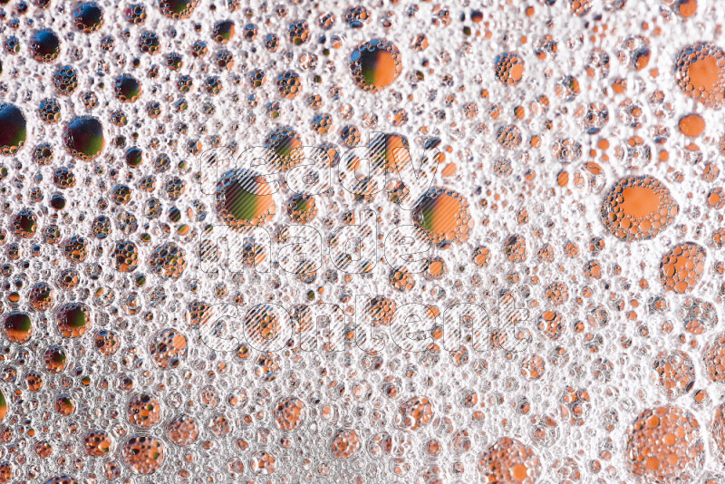 Close-ups of abstract soap bubbles and water droplets on multicolored background