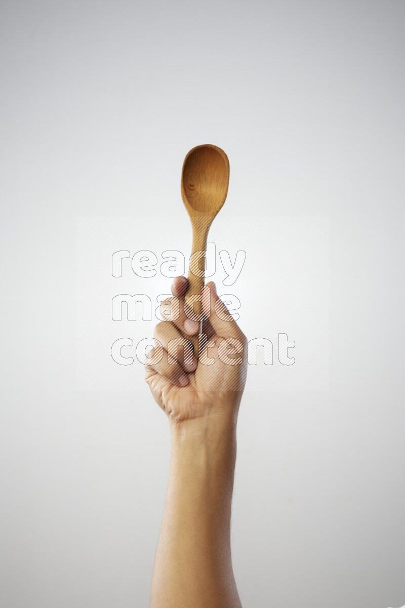Male Hand Holding Wooden spoon on white background