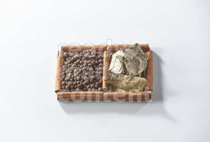 2 squares of cinnamon sticks full of allspice and bay laurel leaves on white flooring