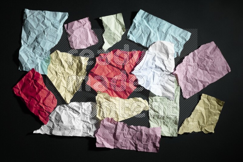Crumpled multicolored paper on black background