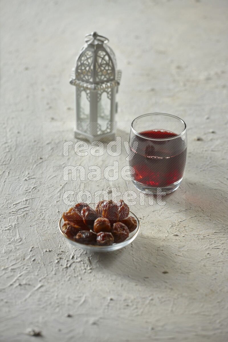 A white lantern with different drinks, dates, nuts, prayer beads and quran on white background