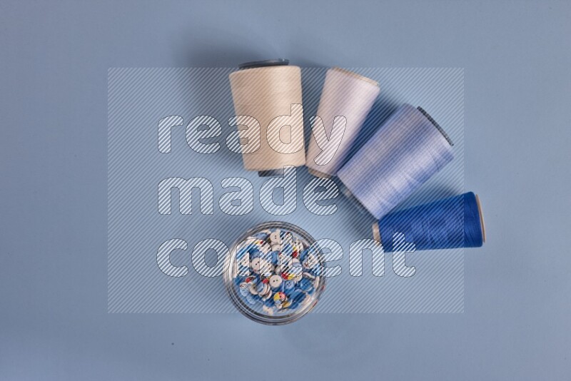 A white collection of sewing and tailoring tools arranged on a blue background
