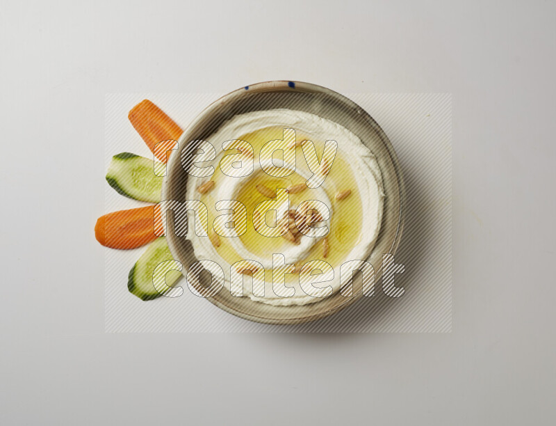 Lebnah garnished with pine nuts in a grey pottery plate on a white background