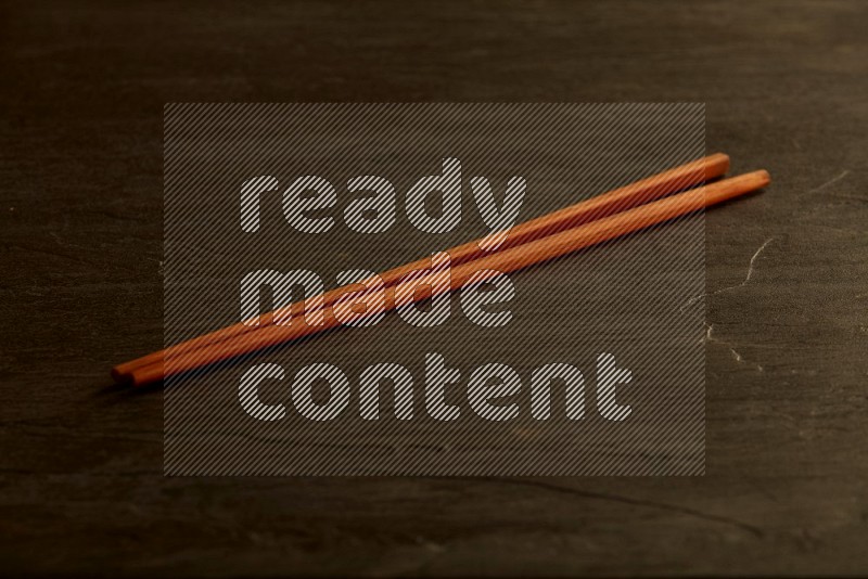 wooden chopsticks on black slate background