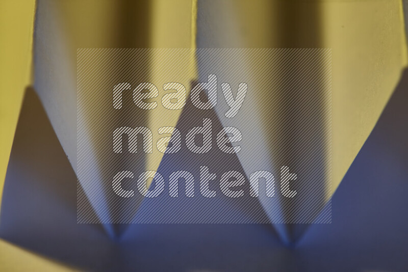 صورة مجردة مقربة تظهر طيات ورقية هندسية حادة بتدرجات اللون الأزرق مع درجات لونية دافئة