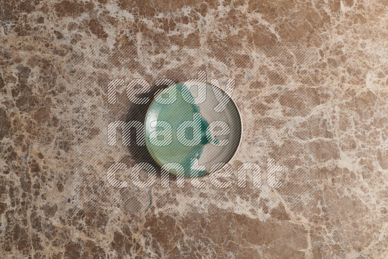 A decorative pottery plate on beige marble background