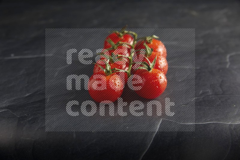 Red cherry tomato vein on a textured black slate background 45 degree