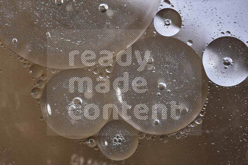 لقطات مقربة لفقاعات من الزيت على سطح الماء باللون الأبيض والبني