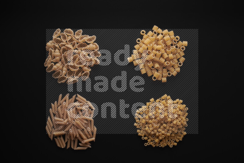 Different pasta types in bunches on black background