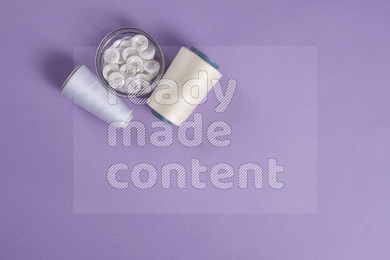 White sewing supplies on purple background