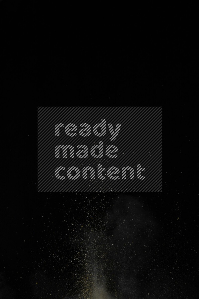 A side view of yellow powder explosion on black background
