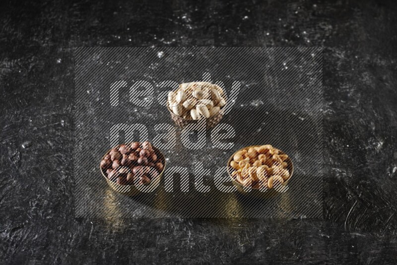 Nuts in a metal bowl in a dark setup