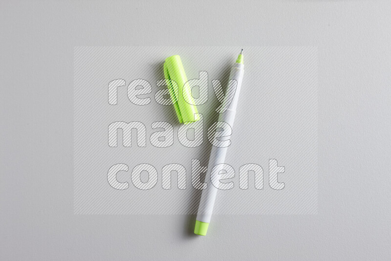 لقطة مقربة تظهر قلم تلوين واحد مفتوح بغطاء على خلفية رمادية