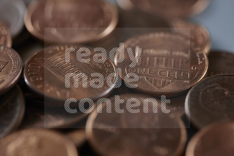 A close-up of scattered United States one cent coins on grey background