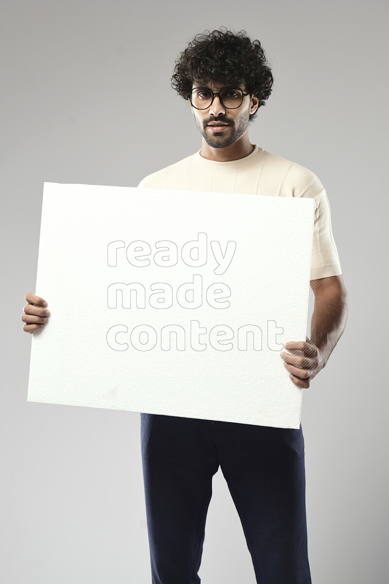 A man wearing casual standing and holding a white board on white background