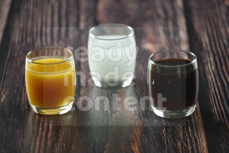 Cold drinks in a glass cup such as water, tamarind, qamar eldin, sobia, milk and hibiscus on wooden background
