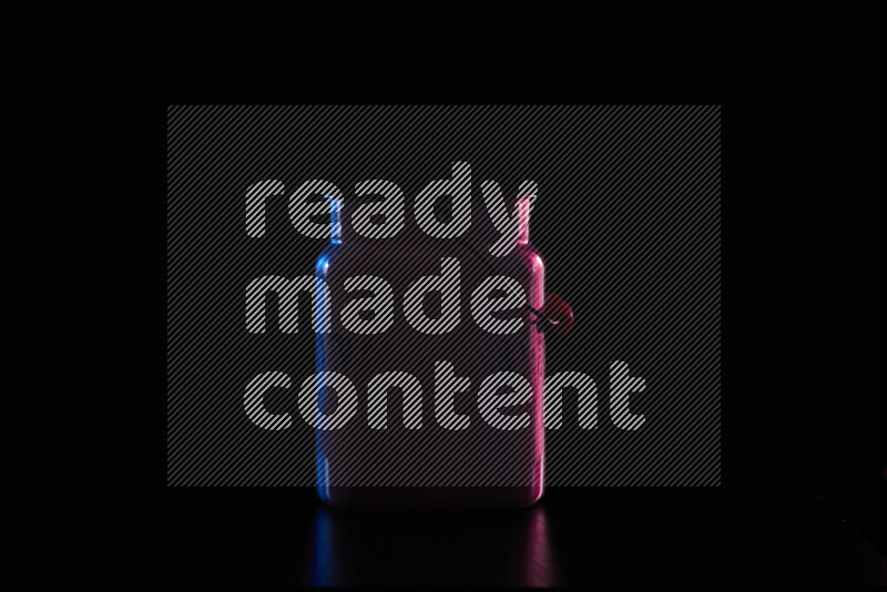 A vintage milk canister with colored rim light against black background