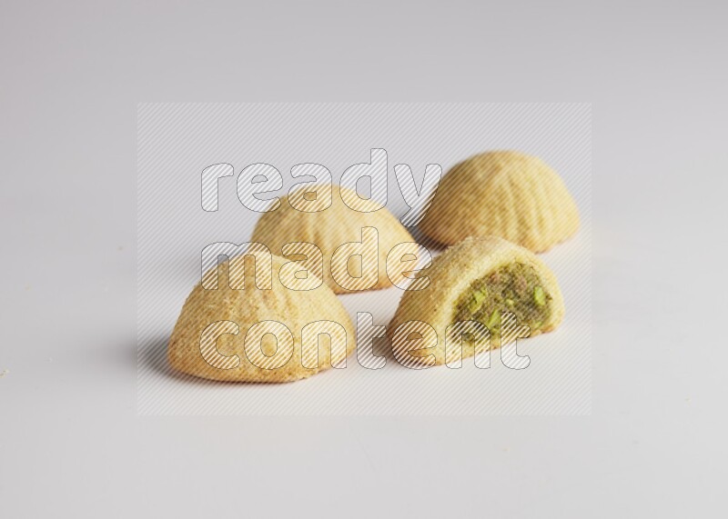 Four Pieces of Maamoul filled with pistachio  paste one of them is cut direct on white background