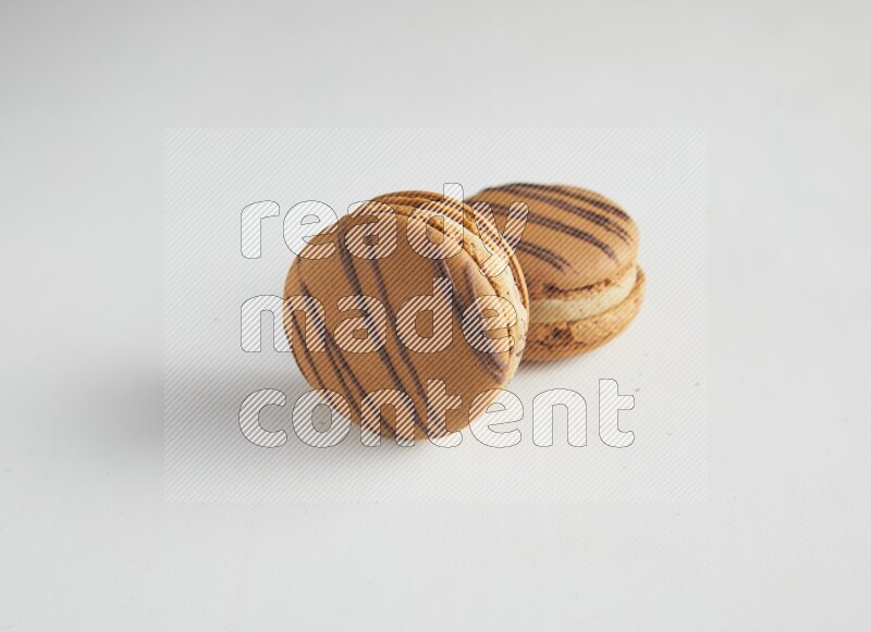 45º Shot of two light brown  Almond Cream macarons on white background