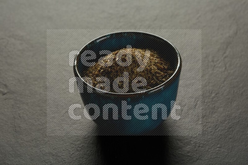 multi color round sauce bowl filled with herbs on grey textured countertop