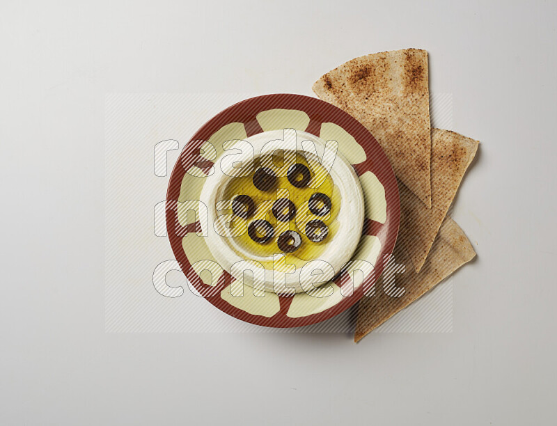 Lebnah garnished with sliced olives in a traditional plate on a white background