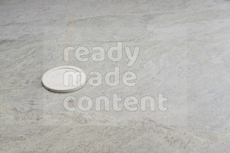 A white pottery bowl's lid on grey marble background