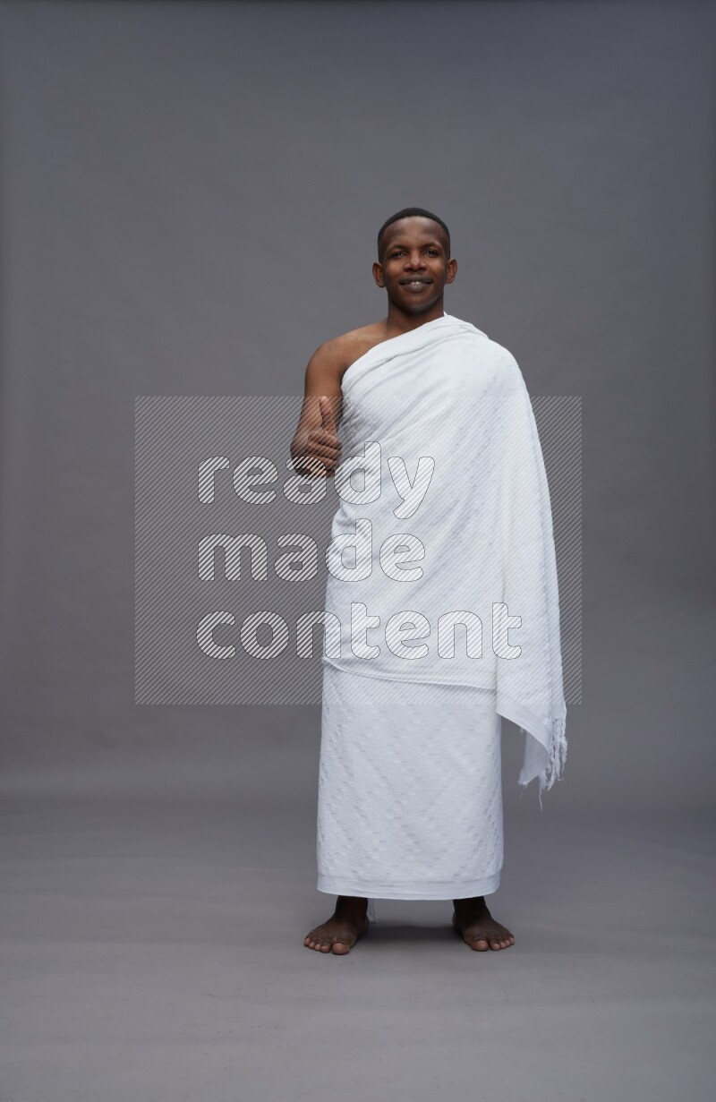 A man wearing Ehram Standing Interacting with the camera on gray background