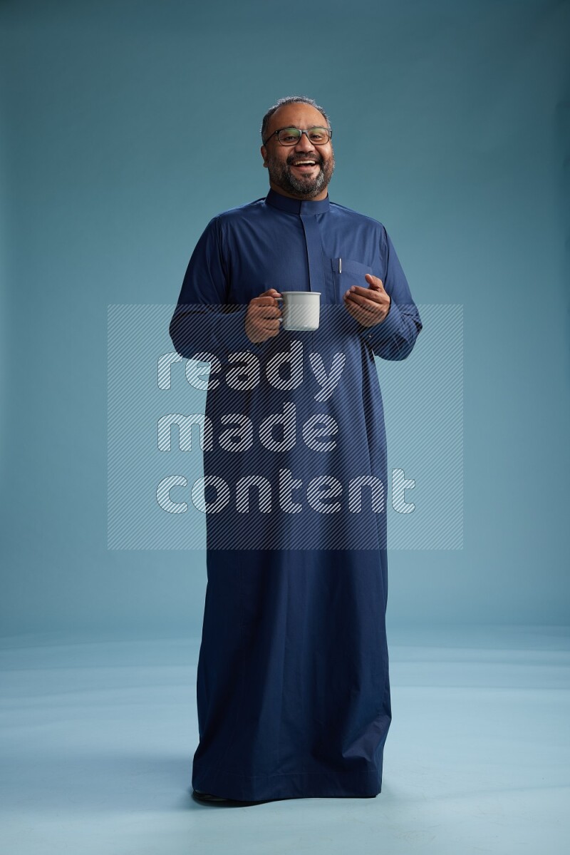 Saudi Man without shimag Standing drinking coffee on blue background