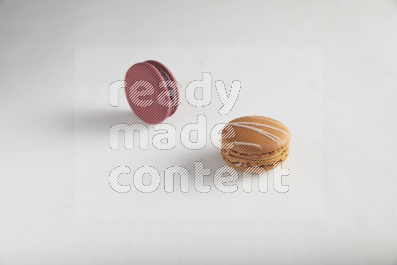 45º Shot of of two assorted Brown Irish Cream, and Red Cherry macarons on white background