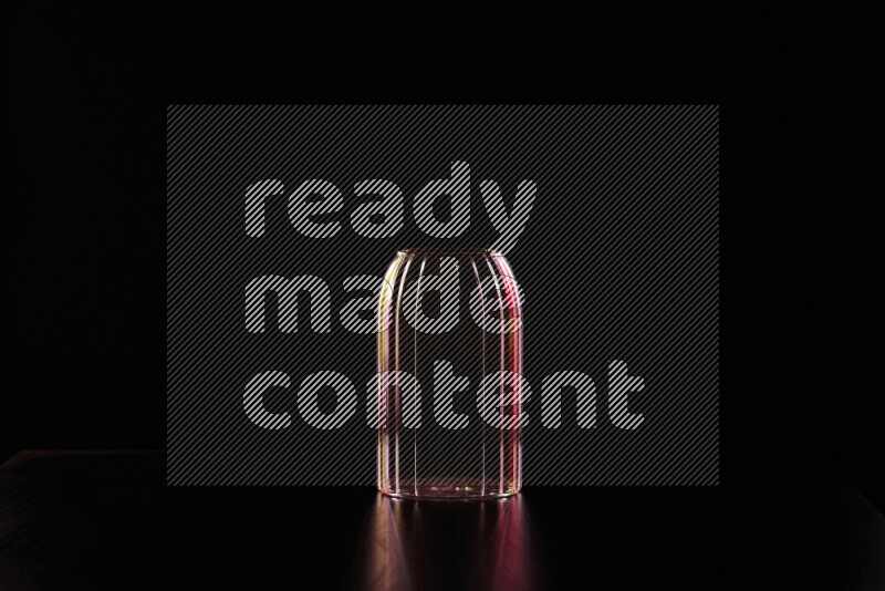 Glassware with rim light in red and yellow against black background