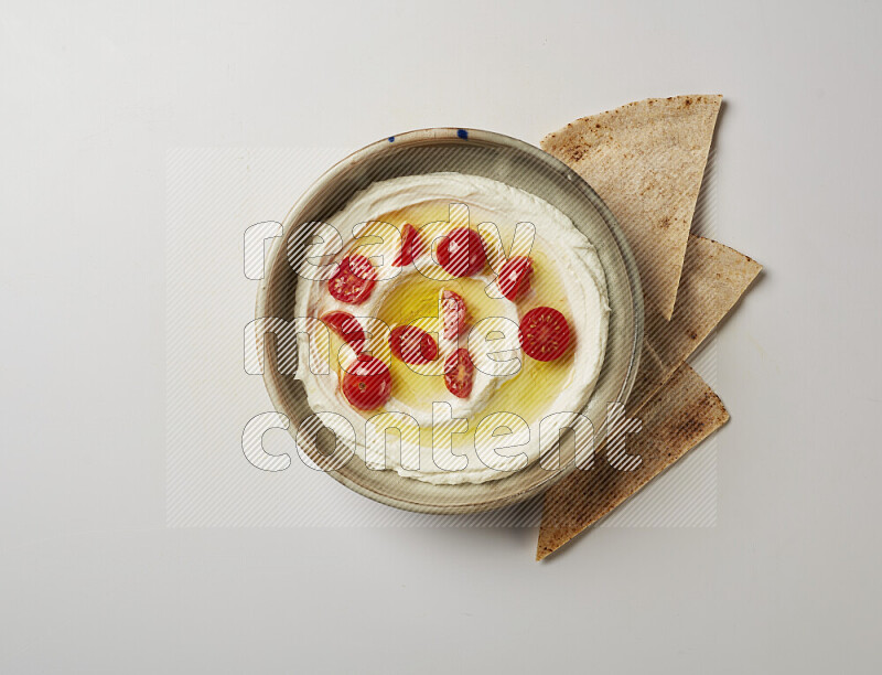 Lebnah garnished with cherry tomato in a grey pottery plate on a white background