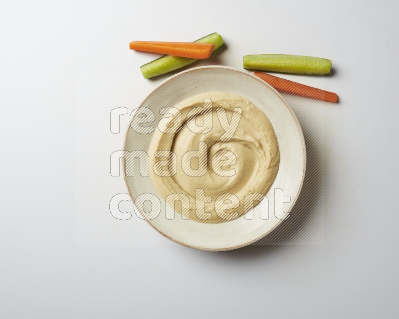 plain Hummus in a pottry plate  on a white background