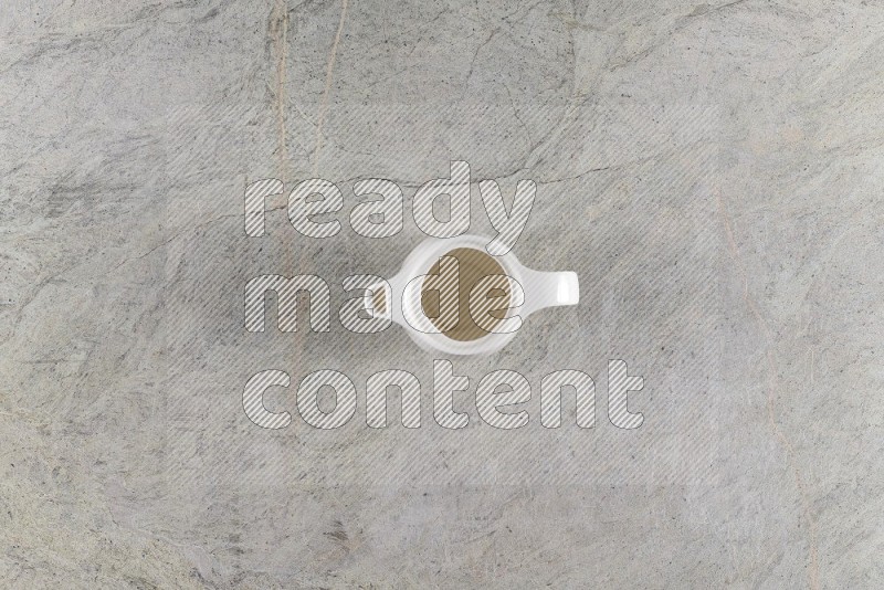 Top View Shot Of A Ceramic Milk Jug On Grey Marble Flooring