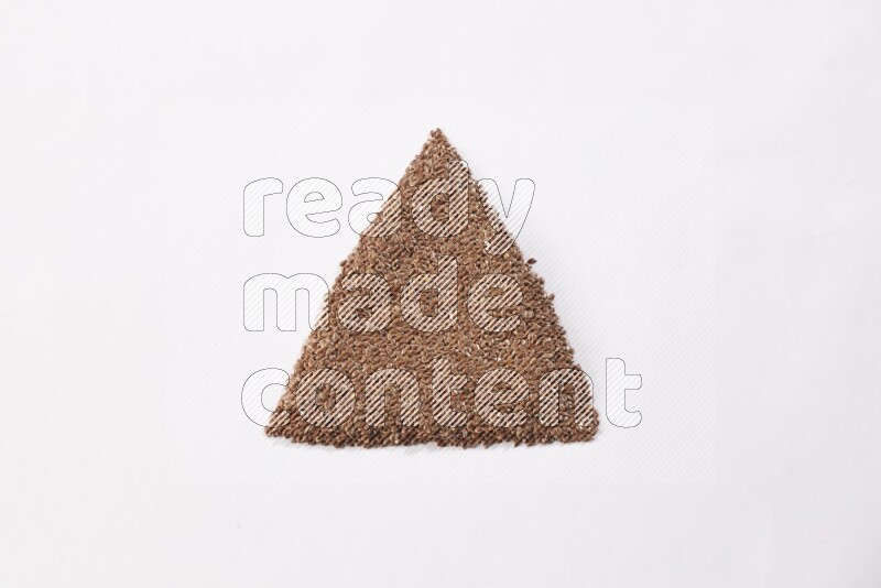 Flax seeds in a triangle shape on a white flooring