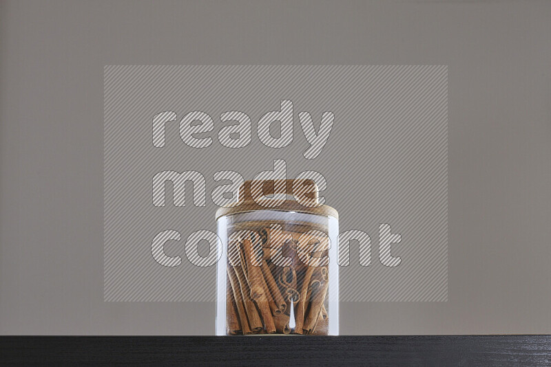 Cinnamon sticks in a glass jar on black background