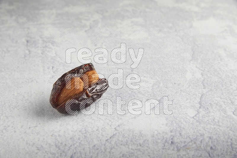 almond stuffed madjoul date on a light grey background